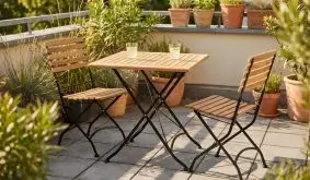 Klapptisch und zwei Klappstühle aus Teak mit schwarzem Stahlgestell auf Balkon