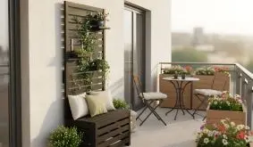 Gemütlicher Balkon mit Sitzbank, Kletterwand und vielen blühenden Pflanzen in Holzpflanzkästen.