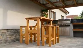 Barmöbel Set Erding aus hellem Holz, Stehtisch mit vier Barhockern untergeschoben auf der Terrasse