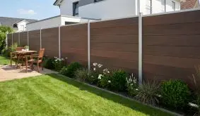 BPC Steckzaun Keitum in Ipé-Holzoptik mit horizontalen Lamellen und Alu-Pfosten im Garten an der Terrasse