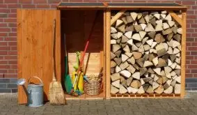 Sparen Sie sich im Garten mit der Kombination aus Brennholzunterstand und Geräteschrank unnötige Laufwege - Die Axt passt spielend direkt neben das gehackte Holz.