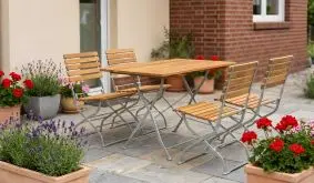 Gartenmöbel Robinie Karlskrona mit vier Klappstühlen und Tisch aus Holzlatten und Metallgestell auf Terrasse