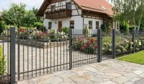 Metall Zaunelemente Bordeaux, anthrazitfarbener Stabzaun mit senkrechten Staketen und Tor an Einfahrt im Vorgarten