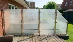 Sichtschutz Milchglas Aalborg Glaszaun mit satinierten Blockstreifen und Metallpfosten, Terrassenabtrennung am Haus