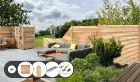Sichtschutz Rhombus aus Sibirischer Lärche mit Lärchenpfosten und H-Pfostenträgern an der Terrasse. Im Set enthalten sind Zaunelemente, Zaunbeschläge, Pfosten, H-Pfostenträger und Durchgangsschrauben.