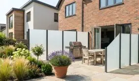 Sichtschutzwand Glas aus satiniertem 8 mm ESG mit dunklen Pfosten, Terrassenabtrennung am Haus