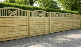 Sichtschutzzaun Rondo aus Holz, grün druckimprägniert, mit geschwungenem Rahmen und Ornamenten, im Garten montiert.