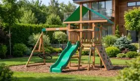 Spielturm für Kleinkinder Bastien aus Holz mit grünem Dach, grüner Rutsche, Nestschaukel, Schaukelsitz und Kletterwand im Garten