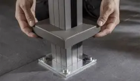 Die Abdeckplatte aus pulverbeschichtetem Aluminium (hier in Anthrazit) wird über die Schraubplatte des Pfostenträgers geschoben. So ist für ein ansprechendes Erscheinungsbild gesorgt