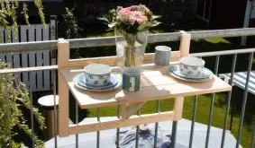 Der 70 x 46 x 11,5 cm Balkonklapptisch aus naturbelassener Kiefer wird am Geländer eingehängt