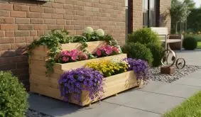 Dreistufiger Holzpflanzkasten mit bunten Blumen vor einer Hauswand, ideal für platzsparende Bepflanzung.