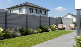 BPC Rhombus Zaun Silkeborg in Steingrau, horizontale Lamellen mit Schattenfugen, im Garten an einer Terrasse