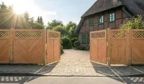 Gartensichtschutz Douglasie, Holzzaun mit Fischgrätfüllung und Rautengitter, geöffnetes Doppeltor an Einfahrt