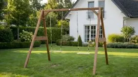 Holzschaukel Julius aus Hemlock-Holz mit zwei Schaukelsitzen, aufgebaut im Garten vor Haus