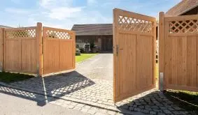 Holzzaun Douglasie Sion Tor aus Holz mit senkrechter Füllung und Rautengitter, an einer Einfahrt im Garten