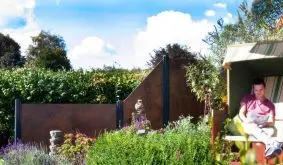 Zum HPL Zaunsystem gehören drei Sichtschutzelemente in Rostoptik. Dank UV-Schutz sind sie sehr farbstabil