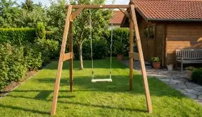 Kinderschaukel Hendrik aus braun gebeiztem Holz mit Brettschaukel auf Rasen im Garten