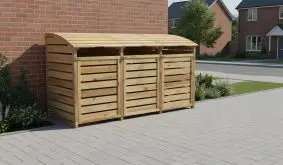 Dreifache Holz-Mülltonnenbox mit Lamellentüren und gewölbtem Deckel steht an Hauswand auf Pflaster.