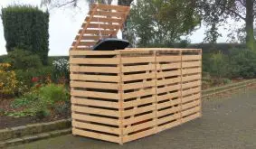 Die Mülltonnenverkleidung (hier in der Variante Natur) ist passend für drei 240 l Tonnen. Kennzeichnend ist eine semi-transparente Bauweise