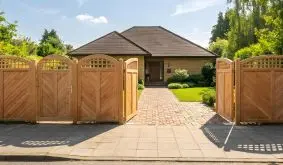 Sichtschutz Douglasie mit Hochbogen, Fischgrätmuster und geöffnetem Doppeltor vor Hauseingang