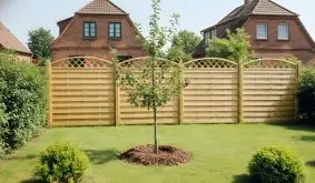 Blickdichter Holz Sichtschutzzaun Berlin Bogen aus druckimprägnierter Kiefer/Fichte mit Rankgitter im Garten vor roten Backsteinhäusern