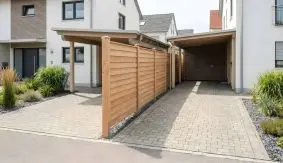 Steckzaun Holz Aarberg aus naturbelassener Douglasie als blickdichter Holz Sichtschutz zwischen zwei modernen Carports in der Einfahrt