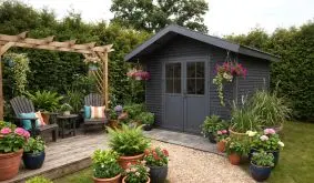 Modernes Gartenhaus in Steingrau im grünen Garten mit Pergola, Sitzbereich und vielen Pflanzkübeln