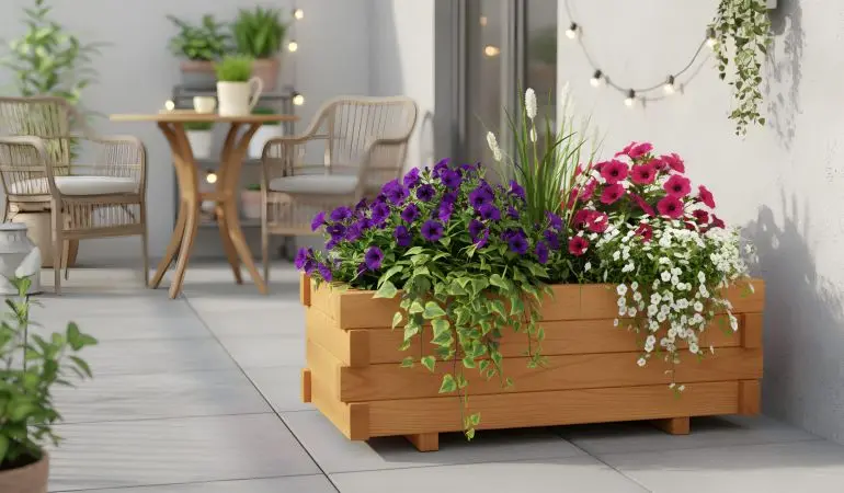 Rechteckiger Holzpflanzkasten mit üppigen Sommerblumen auf modern gefliester Terrasse.
