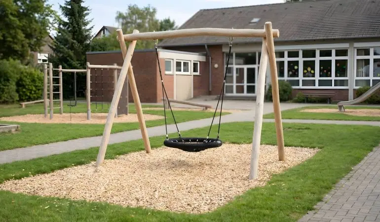 Garten Nestschaukel Robinie Jonas, Rundholz-Schaukelgestell mit schwarzem Nestschaukelsitz auf Kiesfläche im Garten
