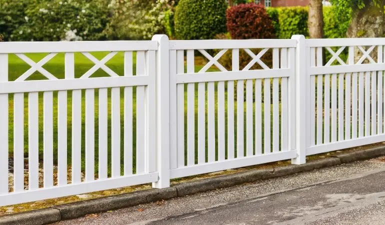 Der weiße Gartenzaun ist mit rostfreien Nägeln und Schlagschrauben verarbeitet, die Tore sind durch diagonale Latten und Stahl verstärkt