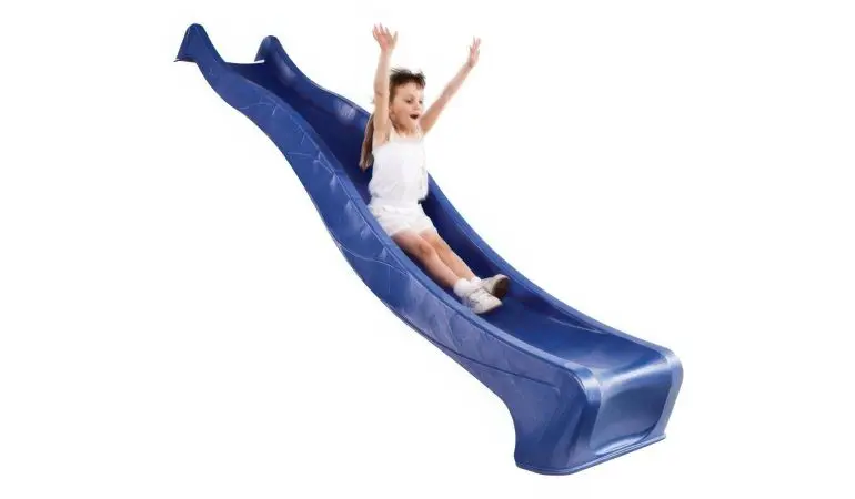 Fröhliches Kind rutscht mit erhobenen Armen eine gewellte blaue Wellenrutsche herunter, Spielplatzrutsche für Kinder