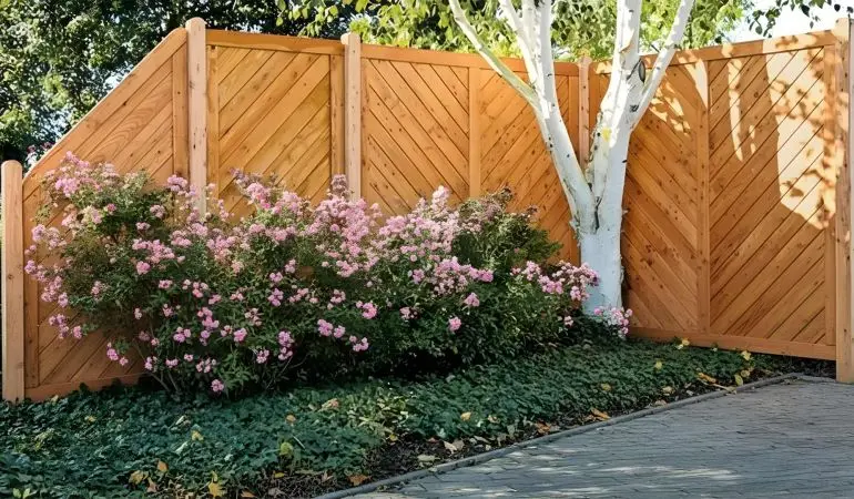 Zaun aus Lärche, gerahmte Elemente mit diagonalen Profilbrettern, als Ecklösung im Garten