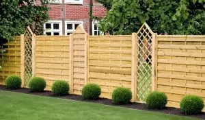 Sichtschutzzaun Berlin Massiv aus Nadelholz mit horizontalen Lamellen und Rankgitter entlang einer Grundstücksgrenze.