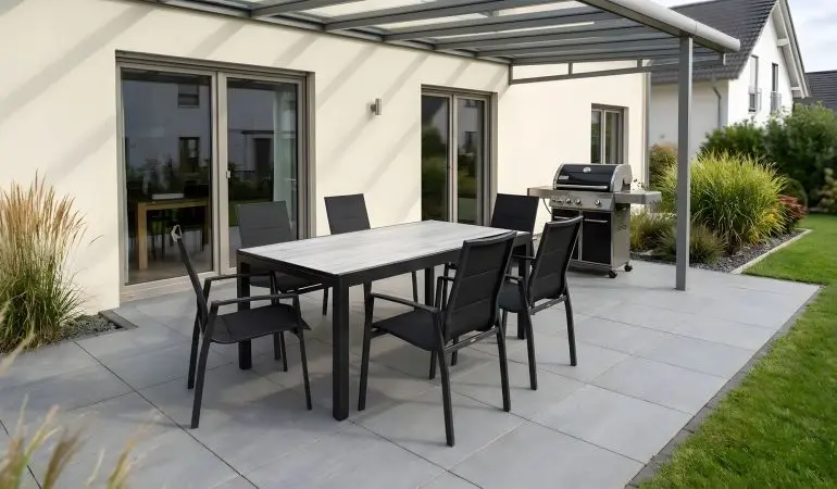 Gartengarnitur Alu Tunis, Alu-Gestell in Anthrazit, schwarze Kunstgewebe-Sessel, Tischplatte in grauer Keramikoptik auf Terrasse