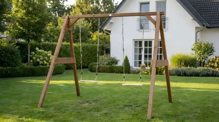 Holzschaukel Julius aus Hemlock-Holz mit zwei Schaukelsitzen, aufgebaut im Garten vor Haus