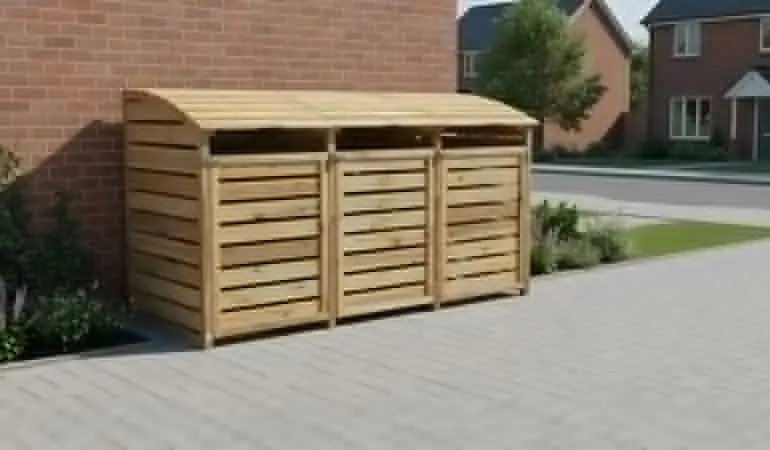 Dreifache Holz-Mülltonnenbox mit Lamellentüren und gewölbtem Deckel steht an Hauswand auf Pflaster.