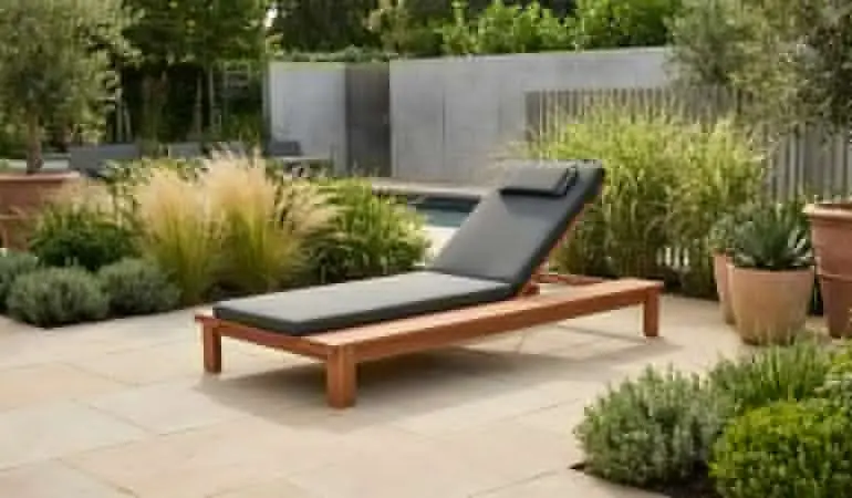 Sonnenliege Holz Cannes aus Naturholz mit dunkelgrauer Auflage und verstellbarer Rückenlehne auf der Terrasse