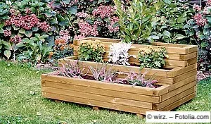 Dreistufiger Pflanzkübel aus Holz mit Kirschlorbeer und Erica