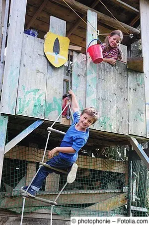 Zwei Kinder spielen im Baumhaus
