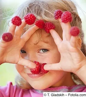 Mädchen mit Himbeere auf jedem Finger