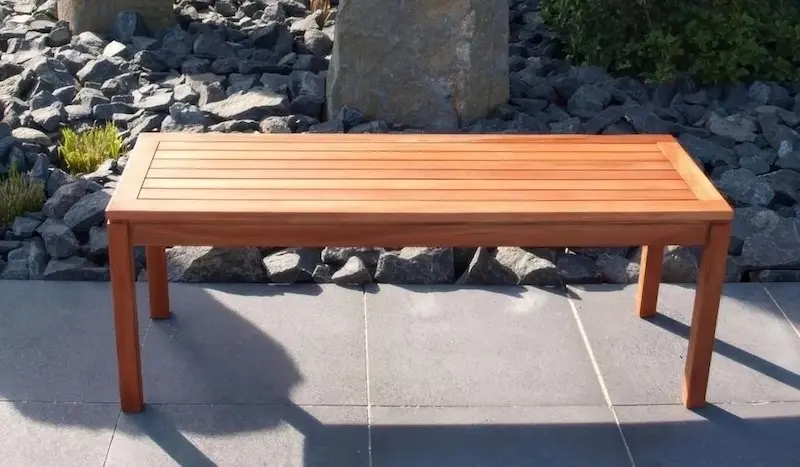 Funktional und schnell einsatzbereit – die Picknickbank Sonnenbeschienene Picknickbank ohne Arm- und Rückenlehnen auf Steinplatten