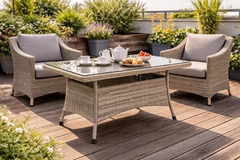Gartentisch aus Polyrattan auf Dachterrasse mit zwei Lounge-Sesseln