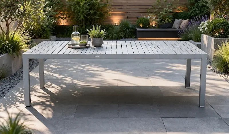 Gartentisch aus Aluminium auf Steinterrasse in modern gestaltetem Garten