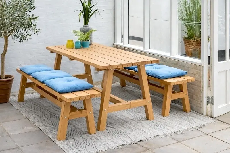 Holztisch mit zwei Sitzbänken auf Terrasse