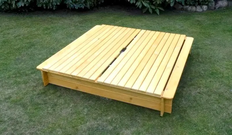 Holzsandkasten mit Abdeckung Geschlossener Holzsandkasten mit zweiteiliger Abdeckung aus Holz im Garten