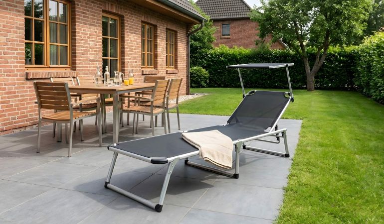 Sonnenliege Ponza mit Dach, silbernes Aluminiumgestell und schwarzes Textilgewebe auf einer Terrasse