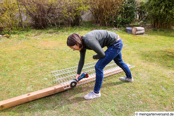 Frau schleift mit Flex Schnittkanten sauber ab